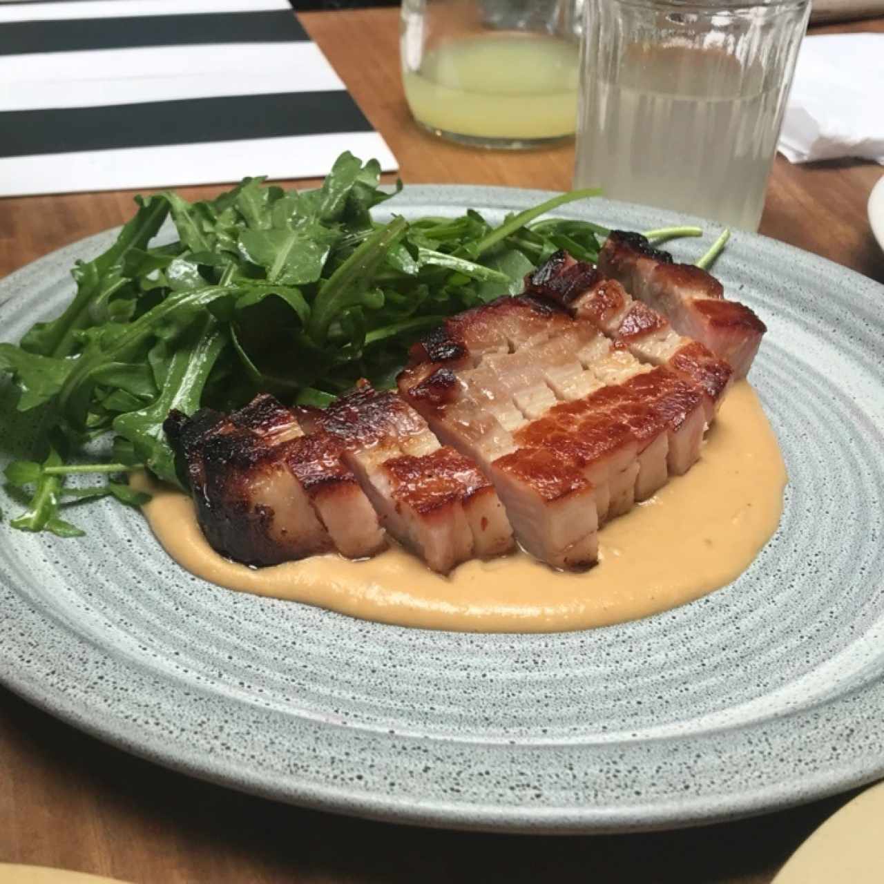 panza de cerdo con ensalada de rugula silvestre y salsa de mani
