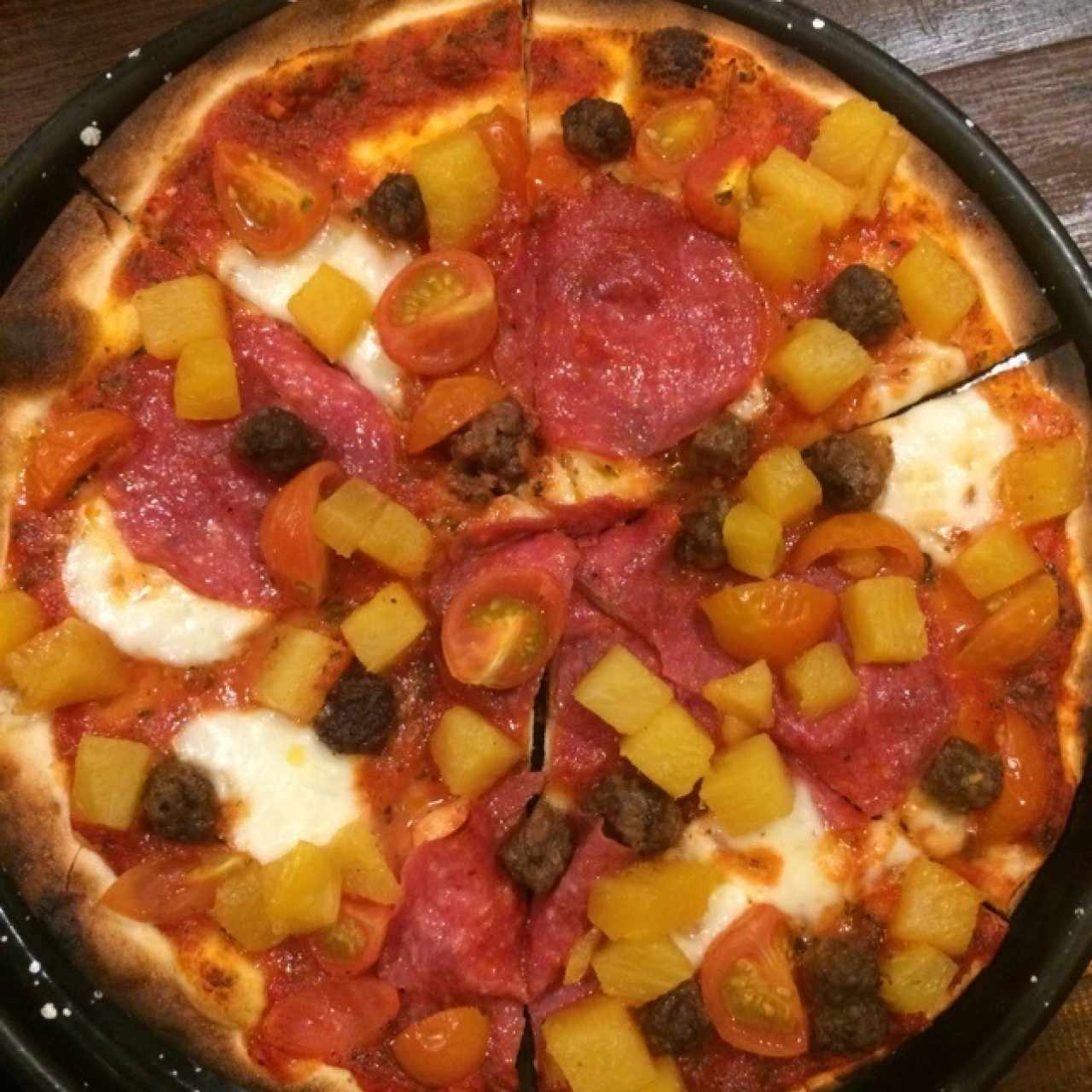 Masa orégano, salsa de la casa (especies), Salami, hamburguesitas, queso bufala, tomate, piña
