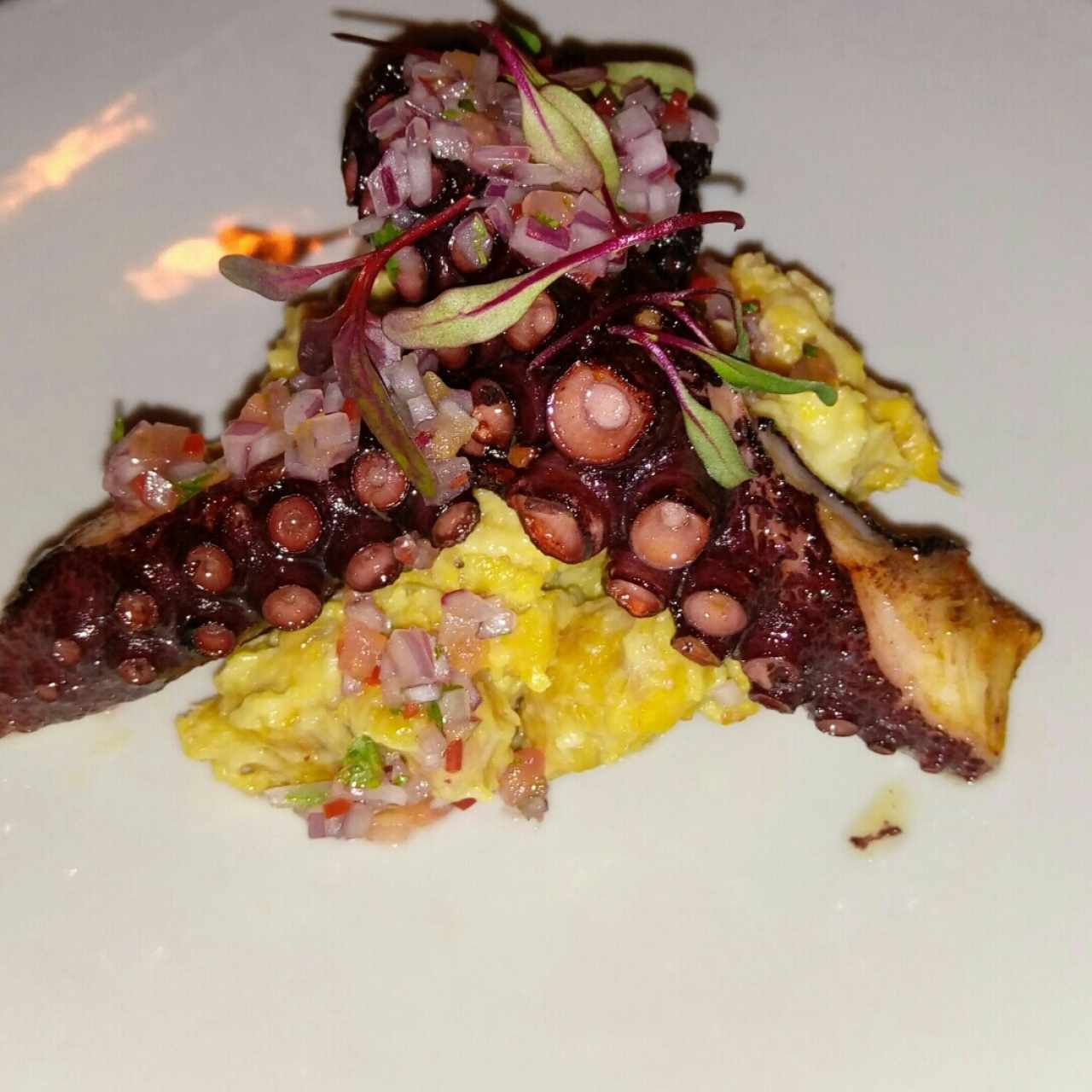 pulpo a la parrilla sobre una cama de plátano 