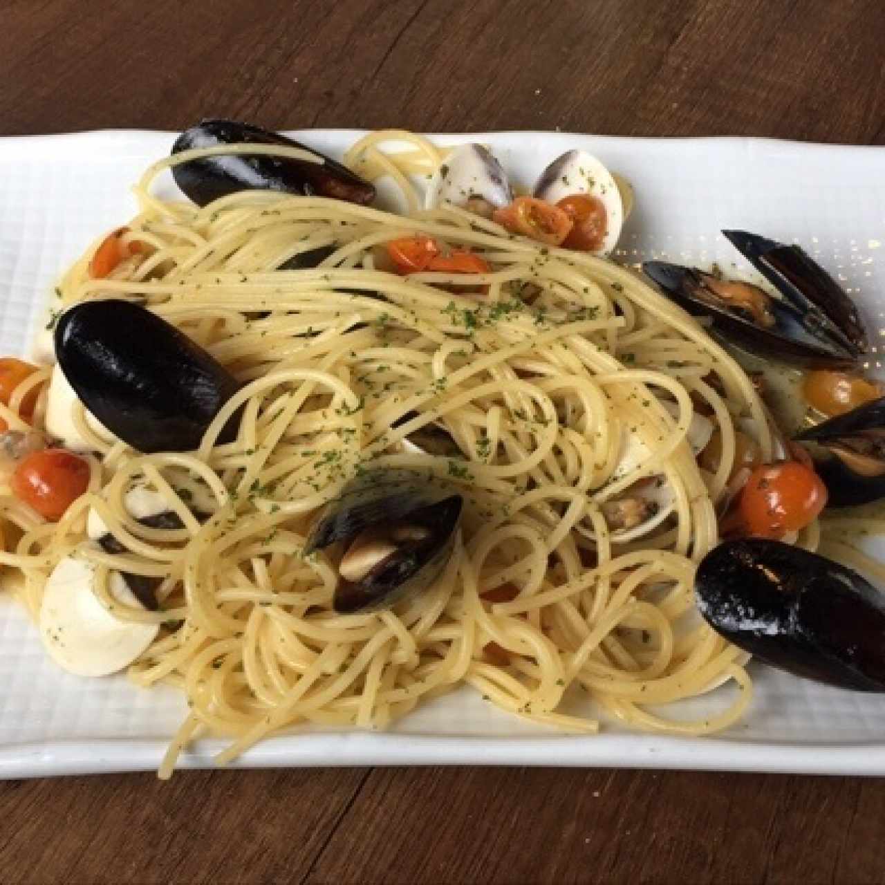Spaghetti con mejillones, almejas y perejil salteadas en aceite de oliva