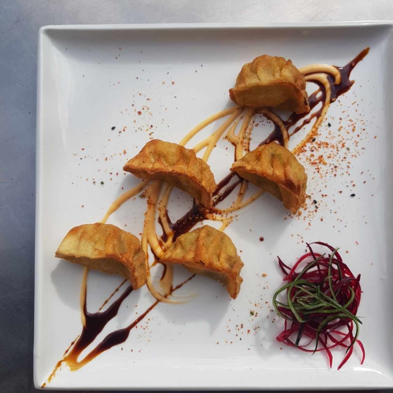 dumplings de anguila y pez tempura con salsa de aguacate