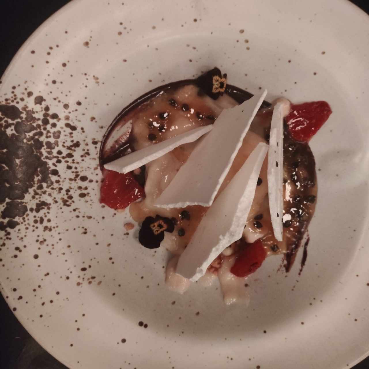 Postre con merengón, fresas ahumadas, maracuyá y chocolate