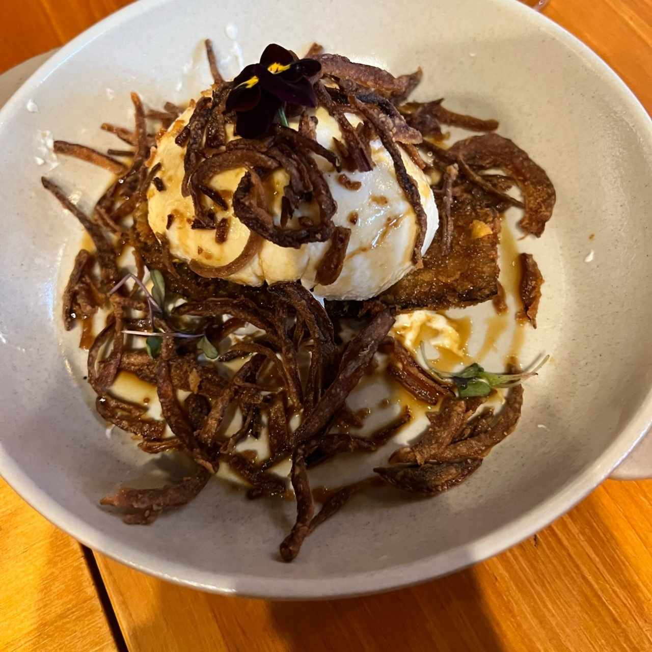 Burrata de cuajada, con berenjena, melao y cebolla frita 