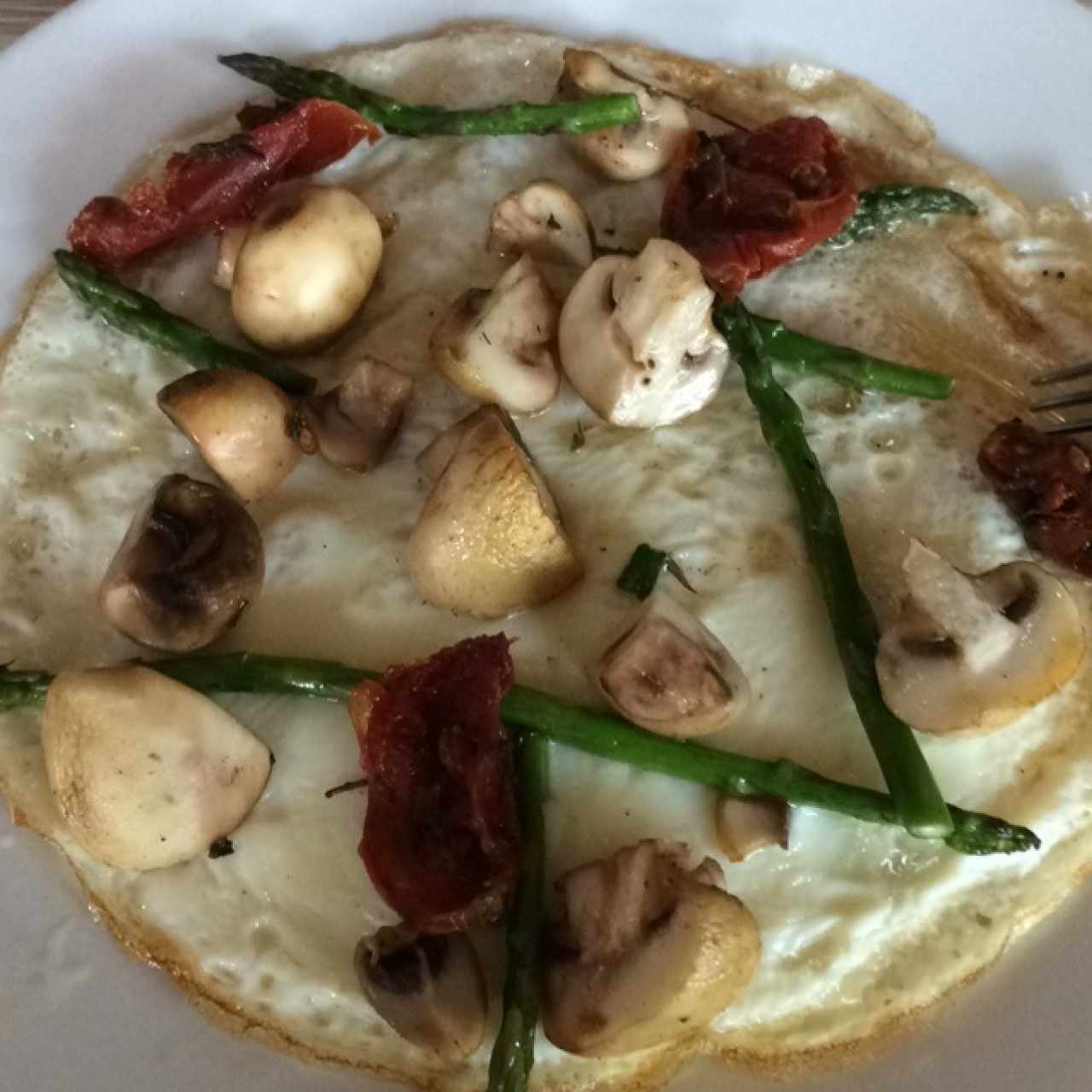 "Pizza" de clara de huevo con tomates secos, champiñones y esparragos