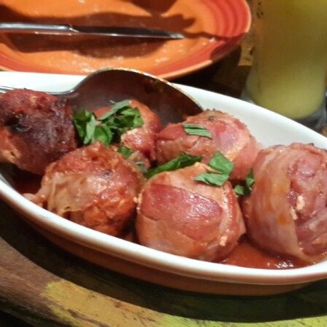Albondigas de chorizo envueltas en tocineta y rellenas de dátiles.
