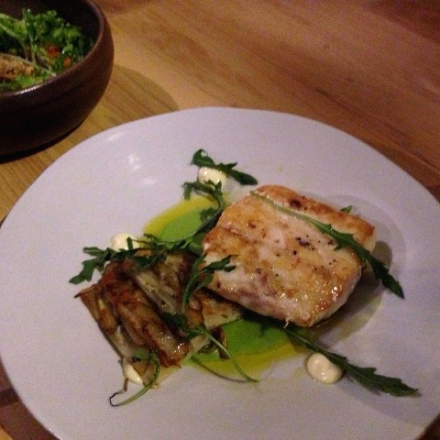 Pesca del día (corvina) con milhoja de papa. Base de crema de arveja