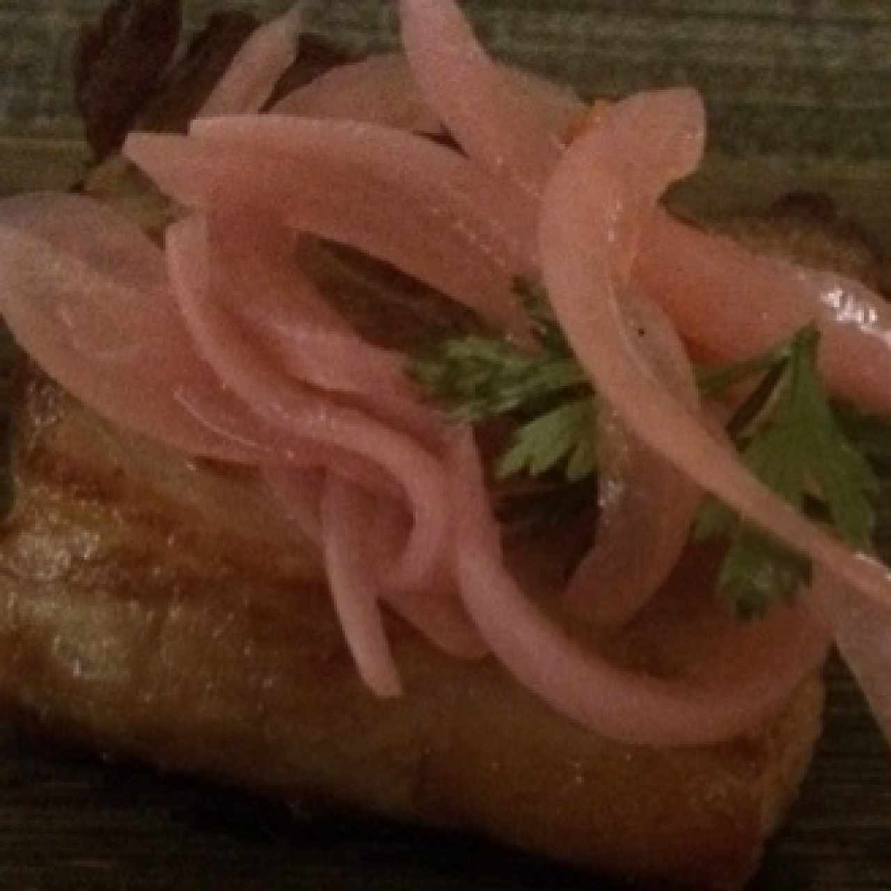 Ceviche de chicharrón, cocinado al vacío en cerveza negra, cebolla escabechada y morrón