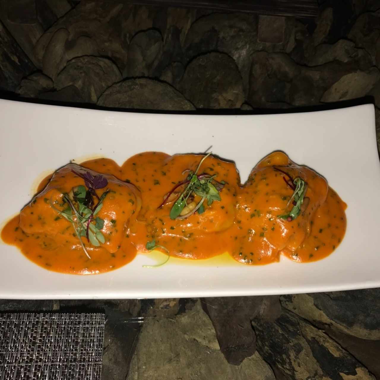 Raviolis de cangrejo, salsa de pimientos  y piñones tostados 