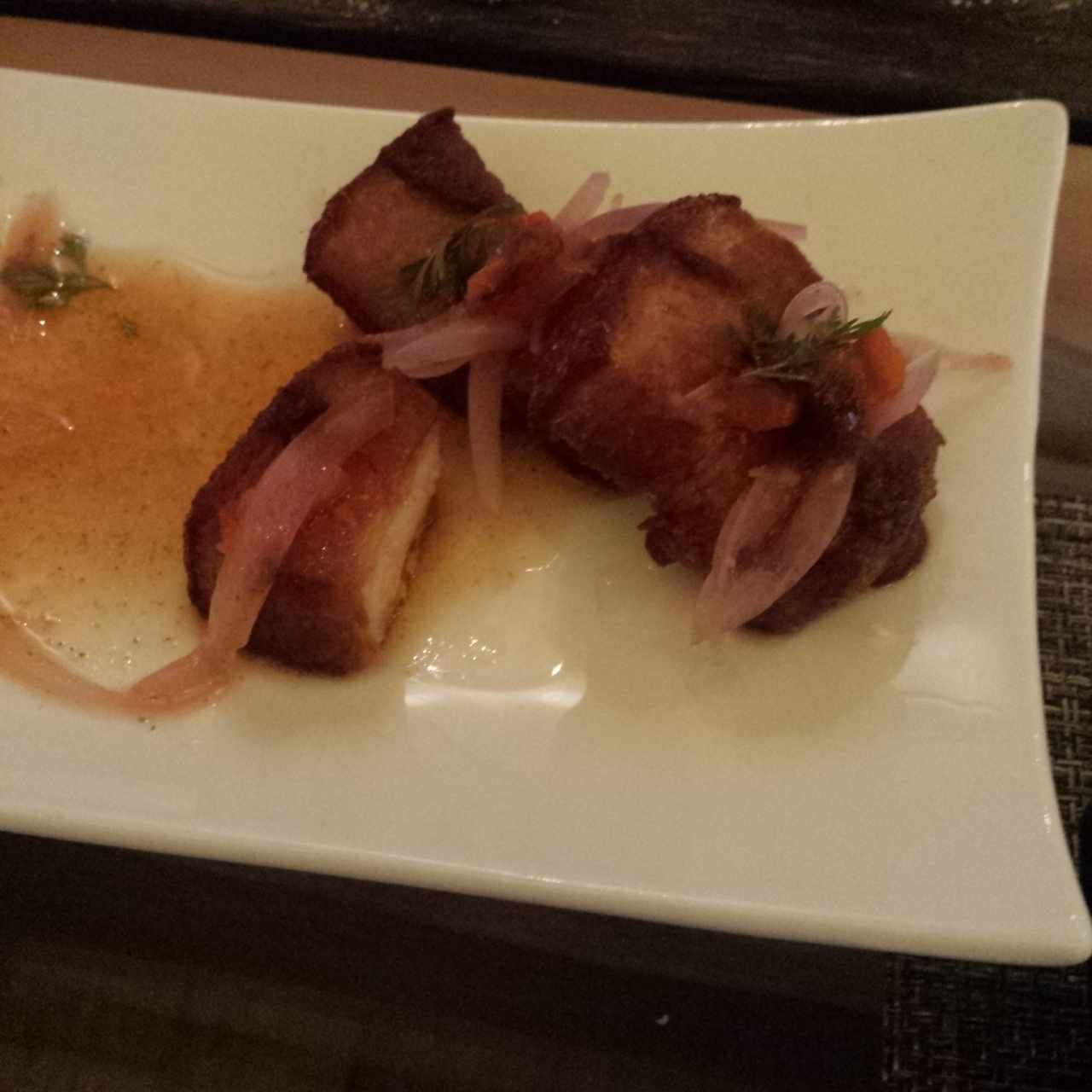 Ceviche de chicharrón, cocinado al vacío en cerveza negra, cebolla escabechada y morrón