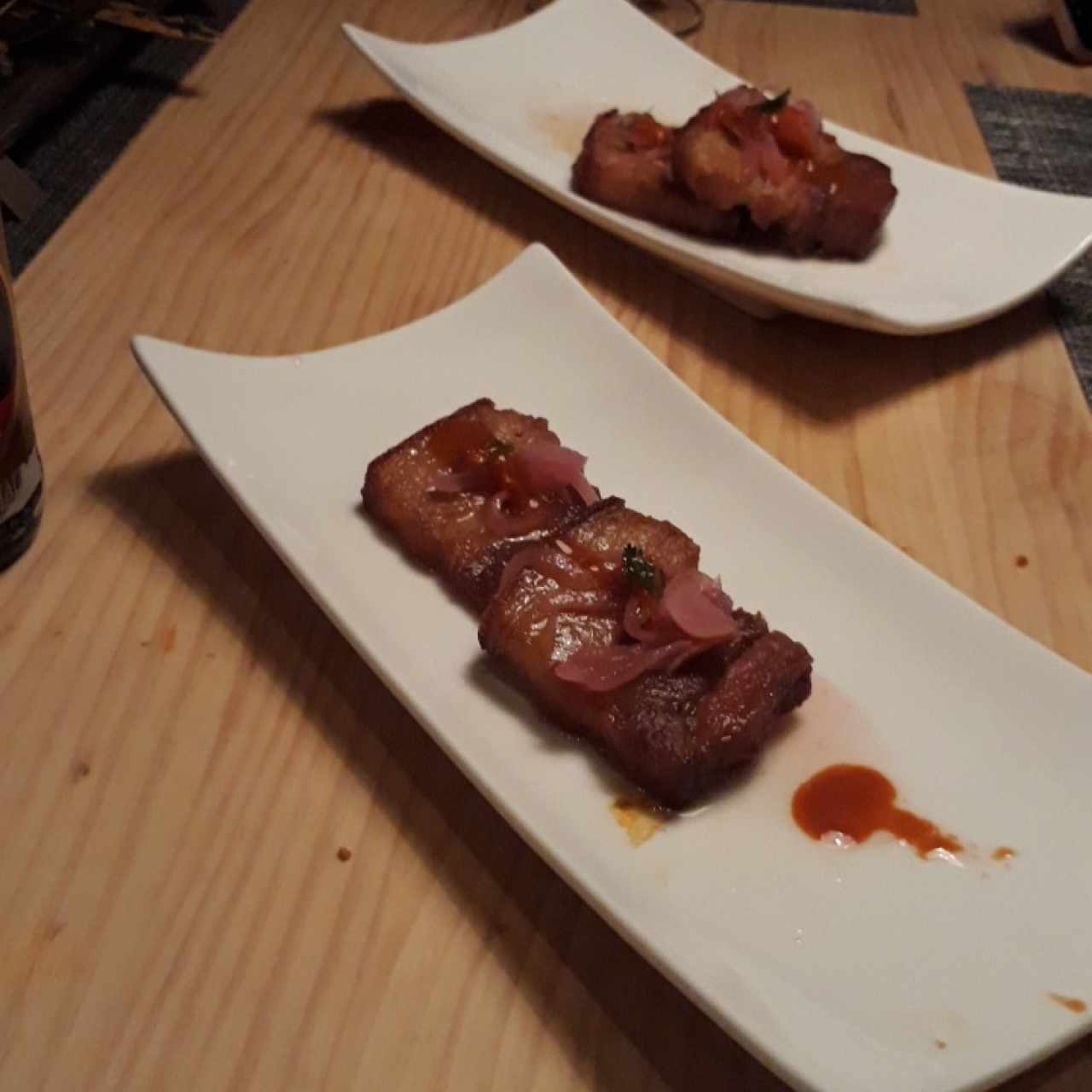 Ceviche de chicharrón, cocinado al vacío en cerveza negra, cebolla escabechada y morrón