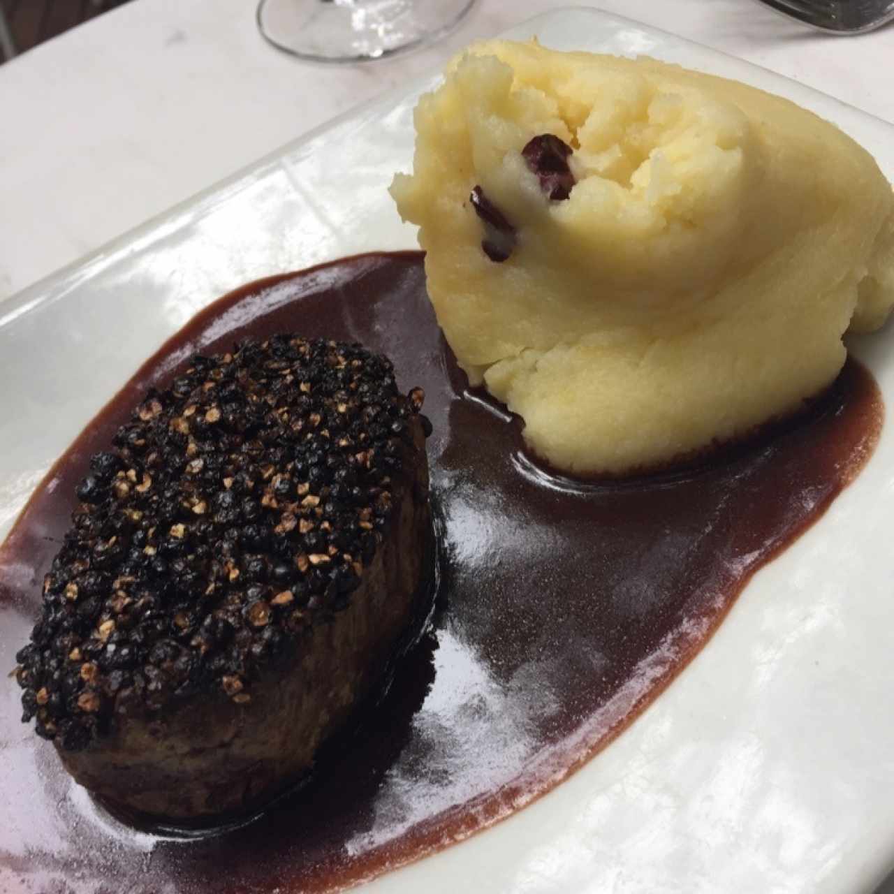 lomo encostrado con pimienta y puré de papa con aceitunas kalamata