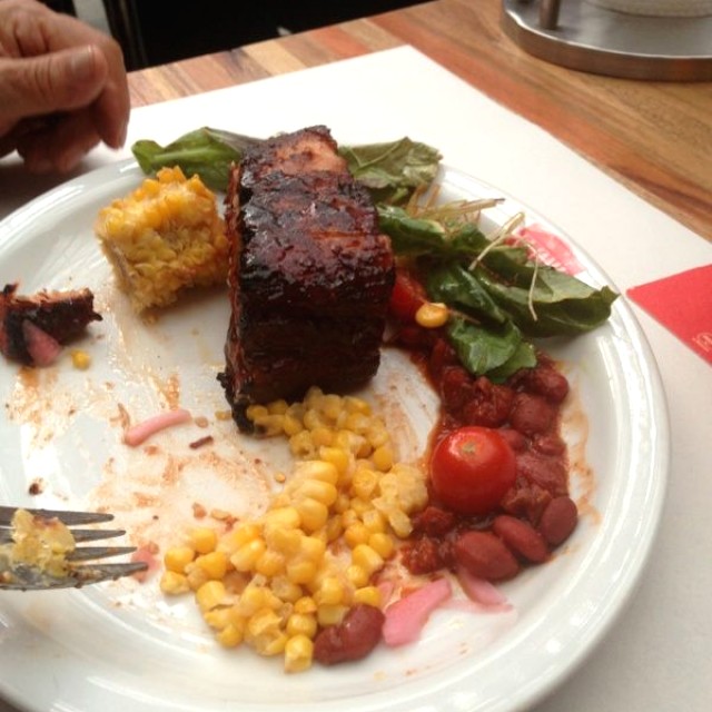 Costillas de cerdo y de acompañamiento, mazorca y ensalada de lechugas 