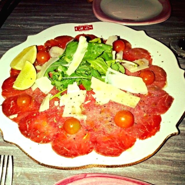 Entrada de carpaccio de lomo con rúgula, queso y tomates cherry