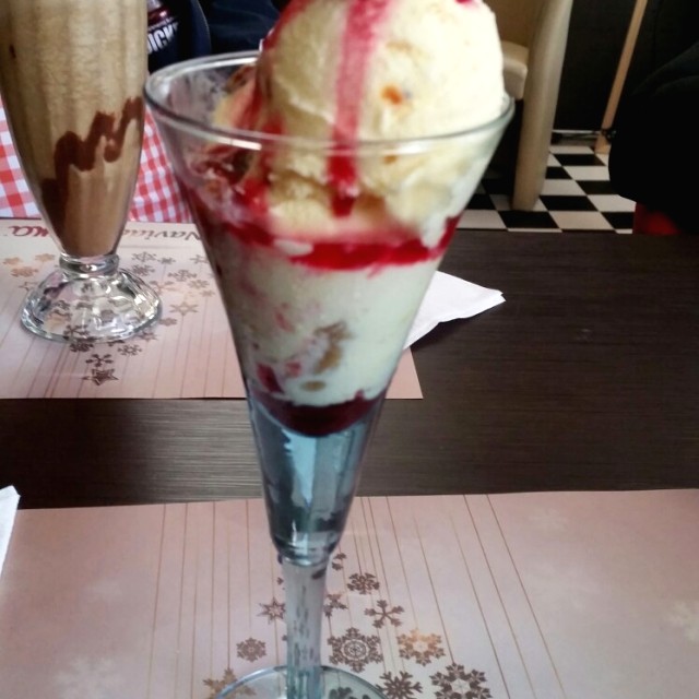 Helado de ron con pasas y salsa de frutos rojos
