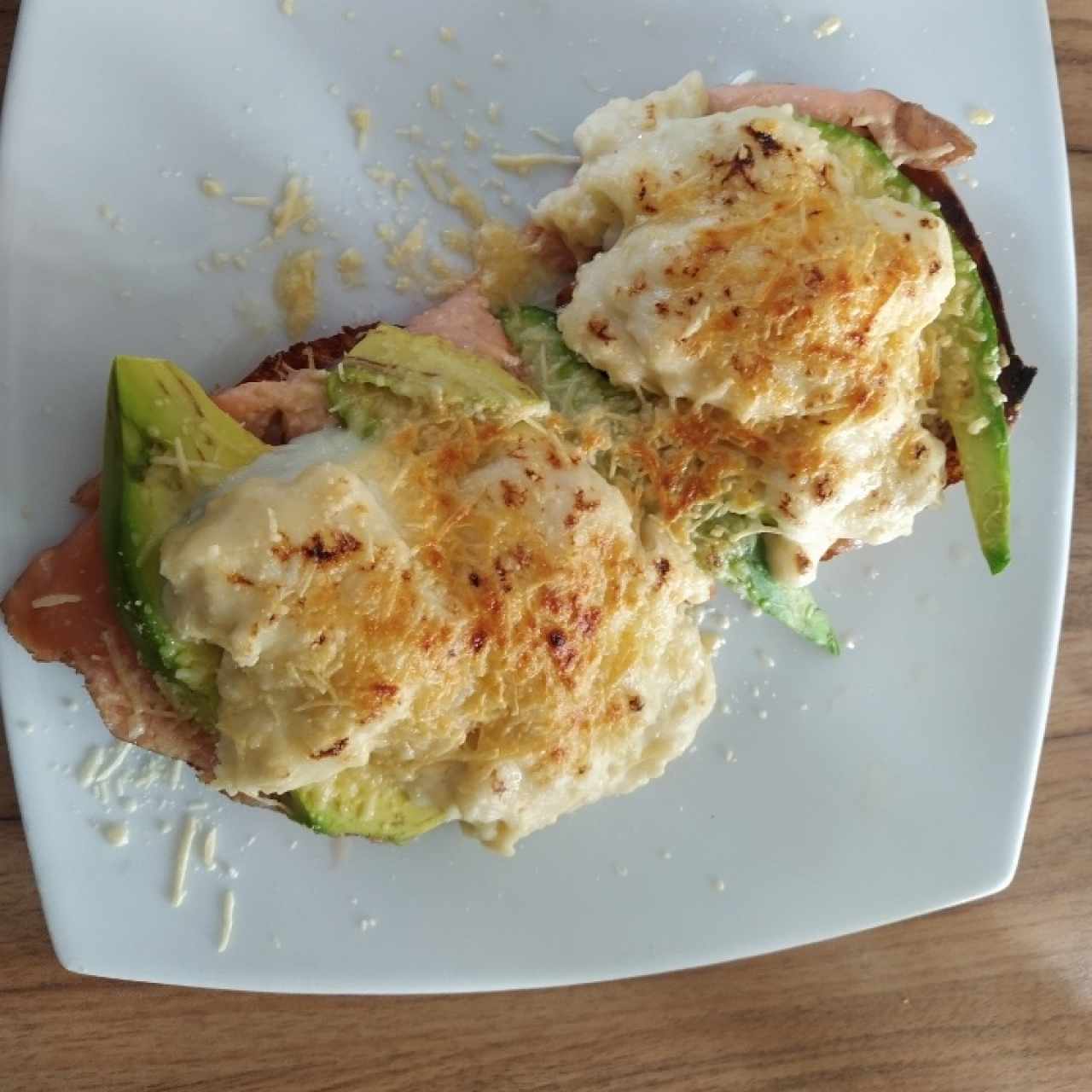 Huevos poché con bechamel, aguacate y salmón gratinado.