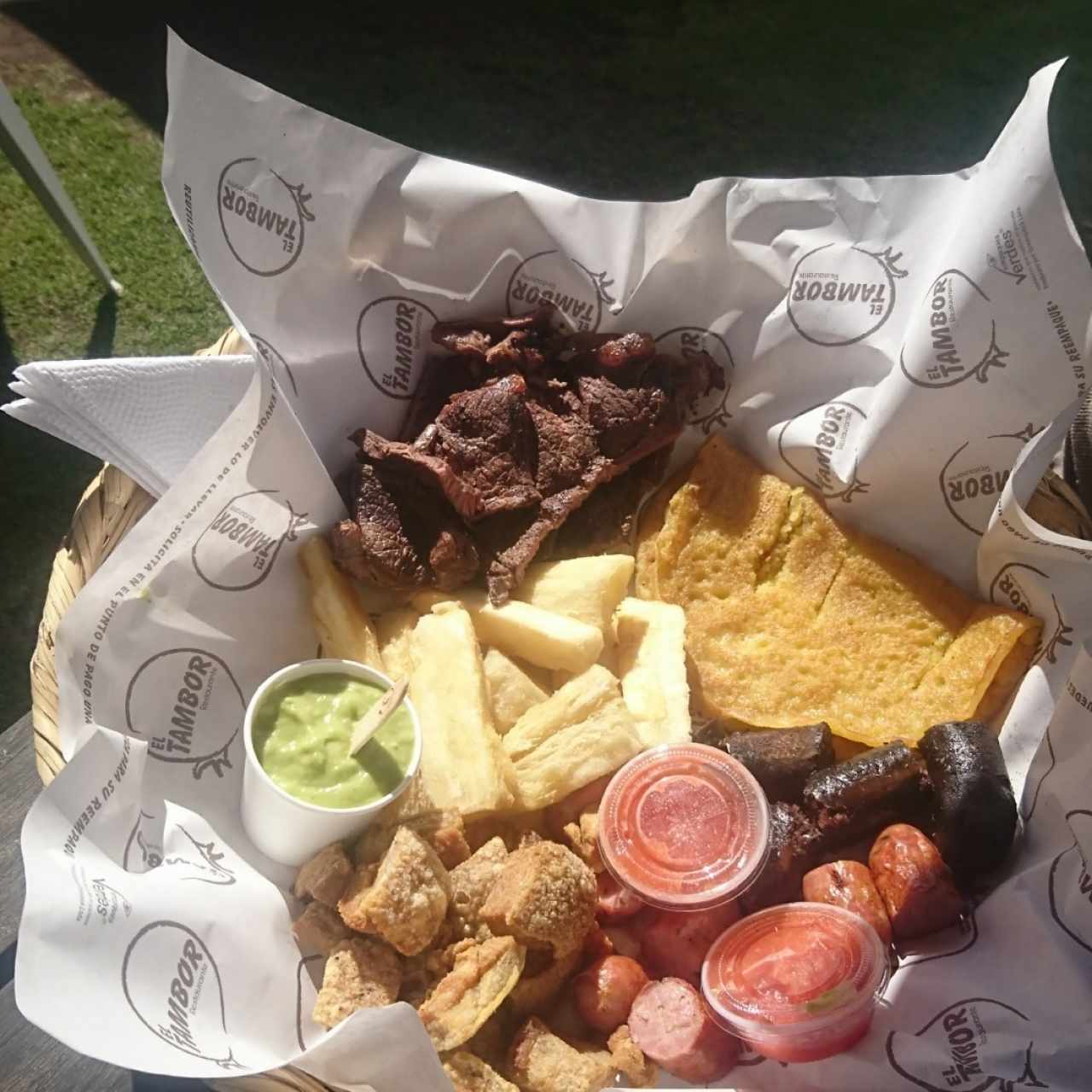 Carne, arepa, yuca, morcilla, chicharrón, chorizo, guacamole y ají. muy bien para tres