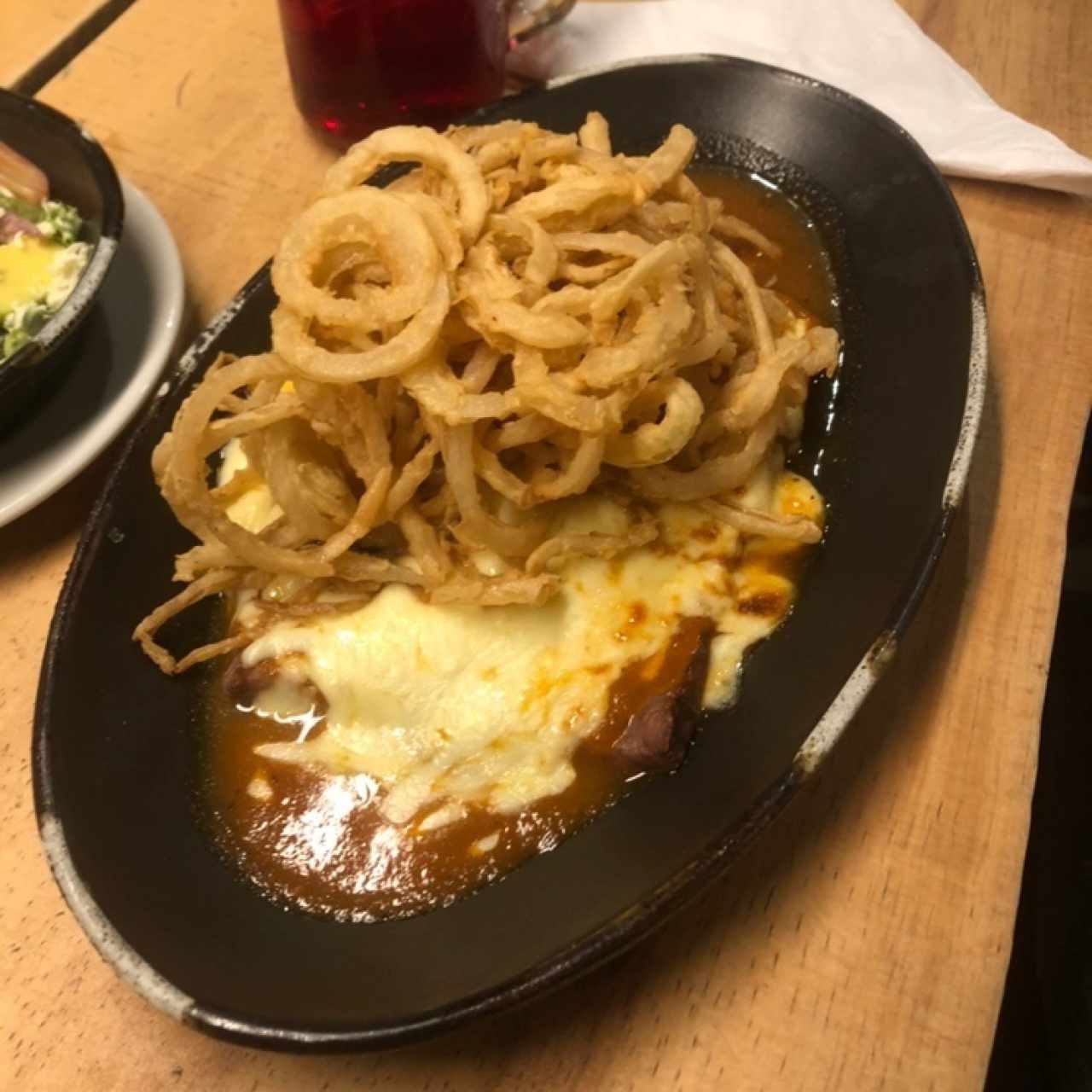 Carne, salsa roja, queso gratinado y aros de cebolla