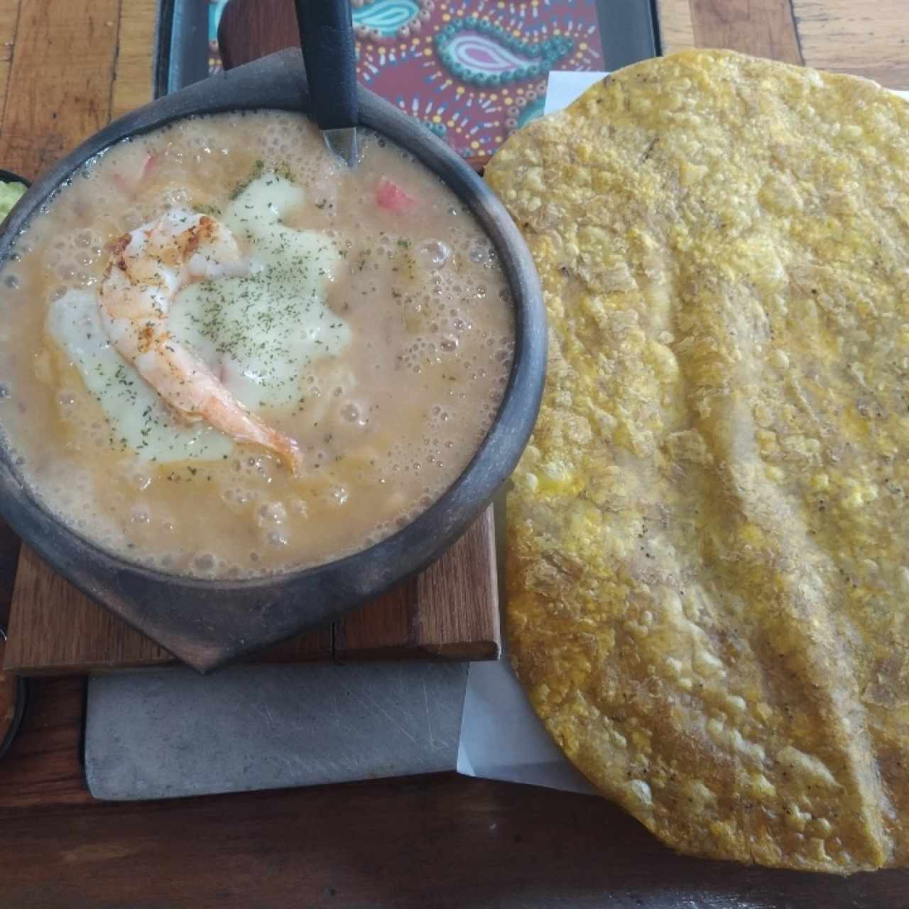 Patacón con cazuela de mariscos, hogao y guacamole