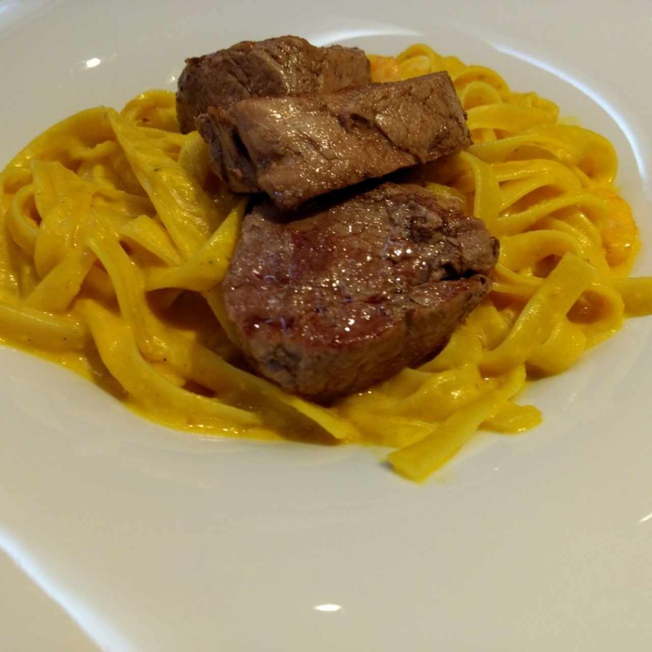 Lomo con fetuchini a la huancaina.