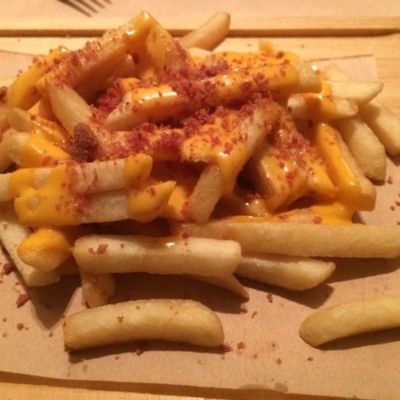 Papas fritas con queso fundido y tocineta