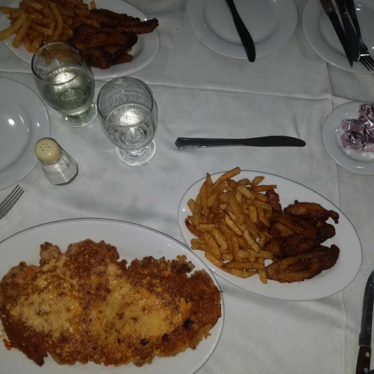 pollo parmesano con contorno  de papitas y tajadas