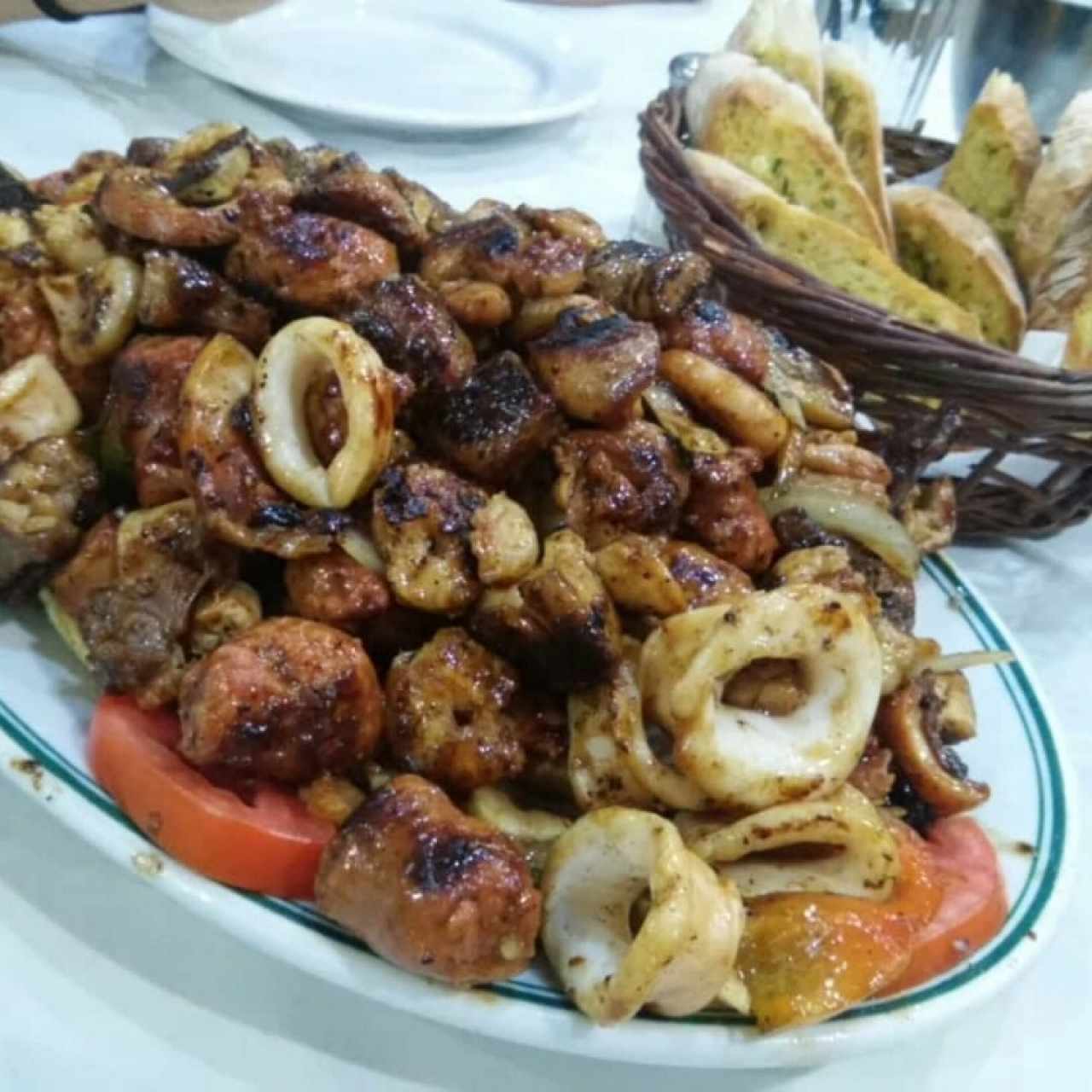 parrilla mar y tierra acompañado con pan con ajo y perejil.