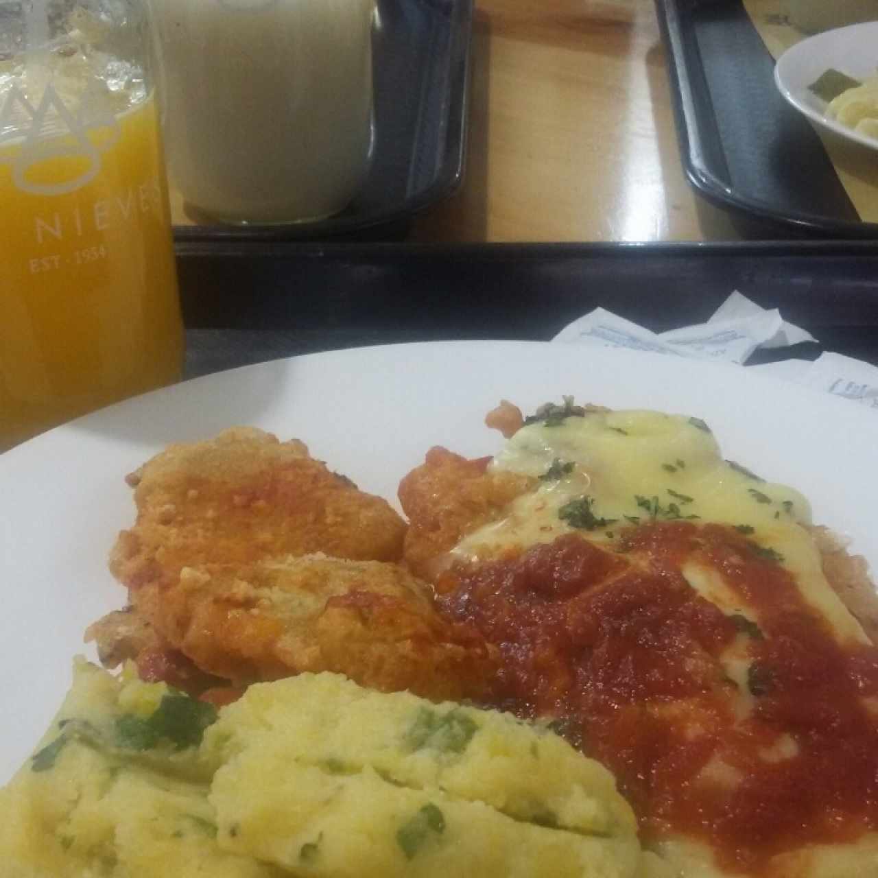 jugo de naranja con milanesa en salsa puré y crocretas de queso  