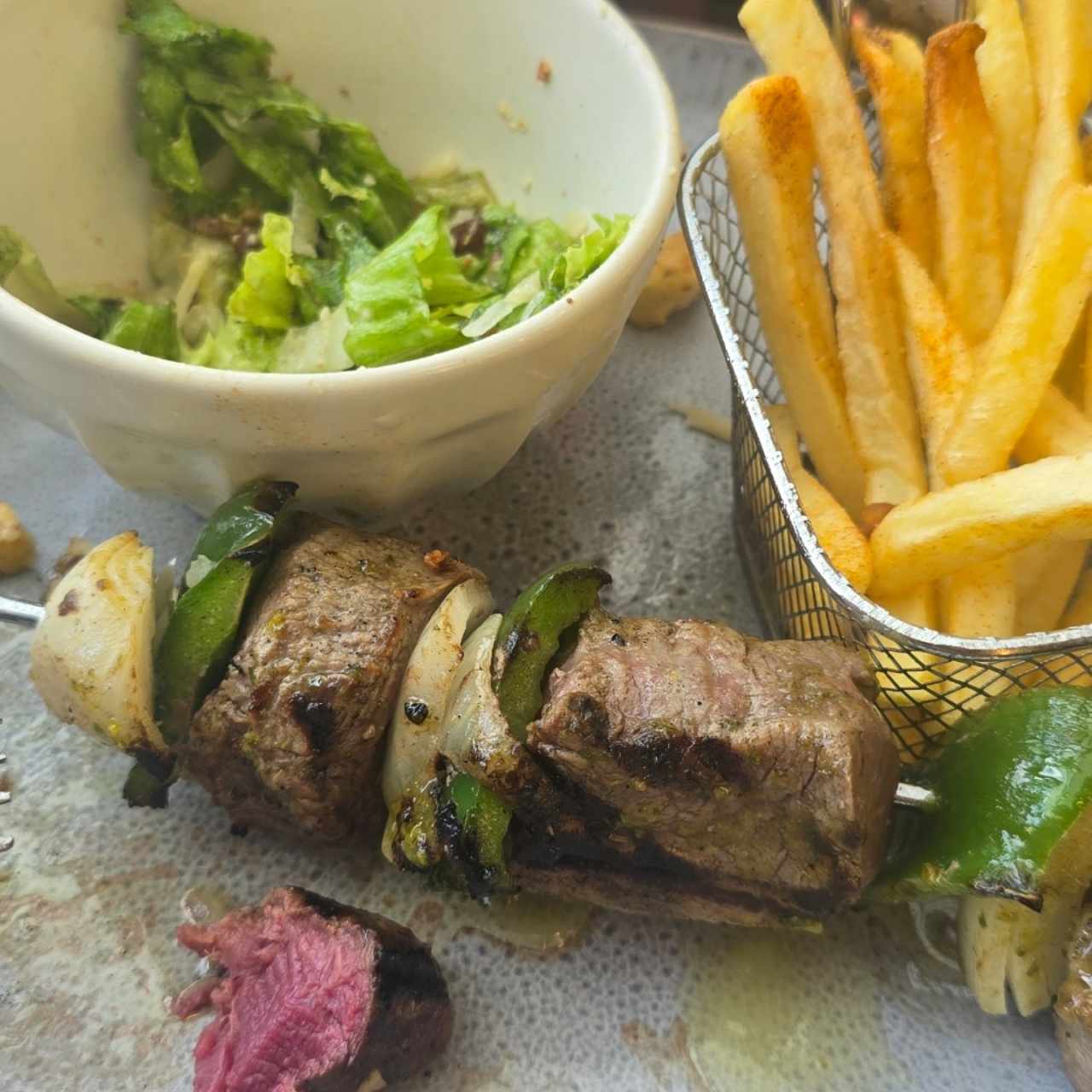 Pincho de lomito. viene con papitas y una pequeña ensalada césar
