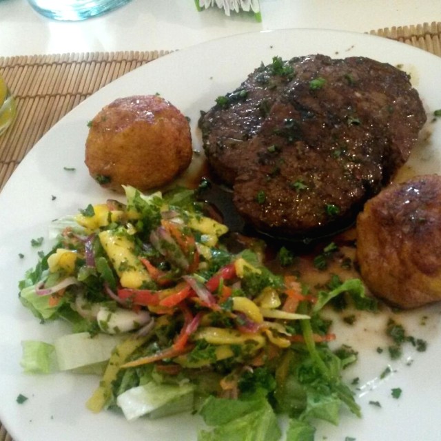 Medallones de lomito en salsa de ron de coco, acompañado de buñuelos de plátano y ceviche de mango