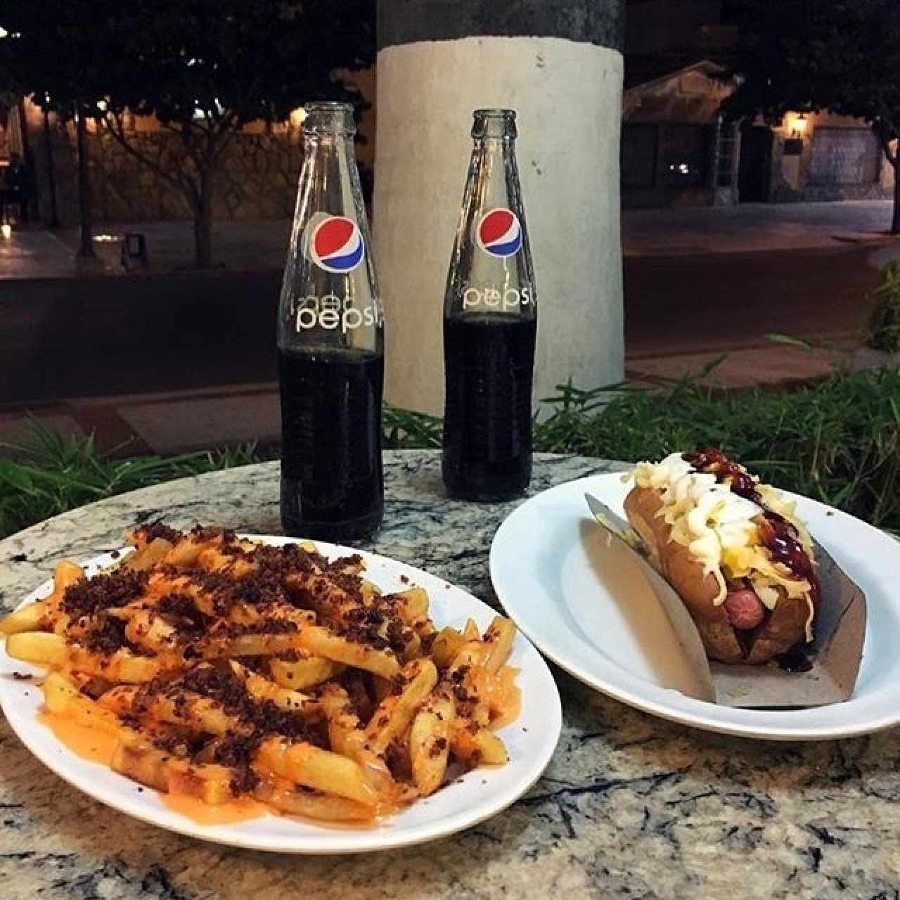 Papas con queso cheddar y tocineta. Perro caliente