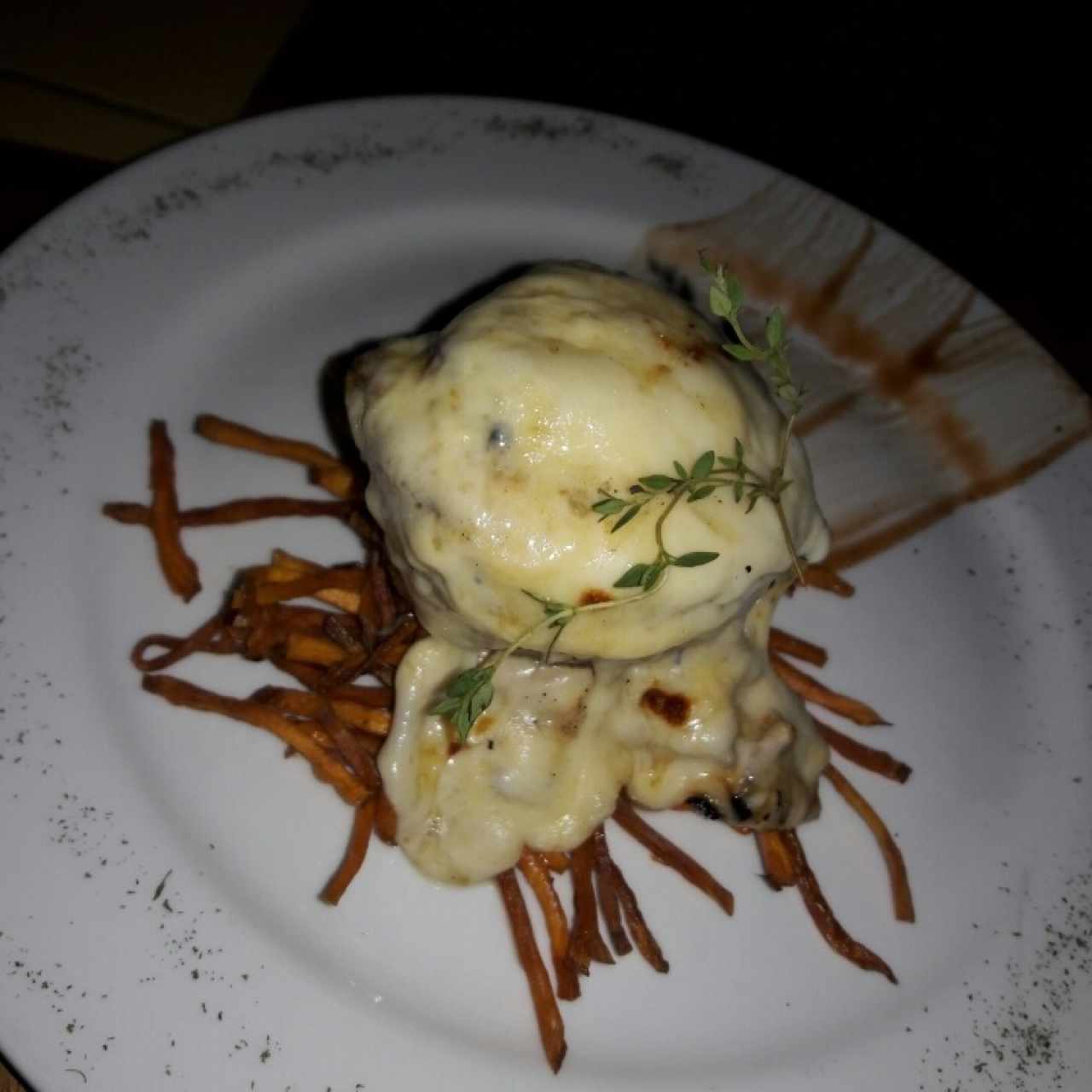 lomo de cerdo relleno de platano gratinado con queso mozarella sobre tiras de batata crocante