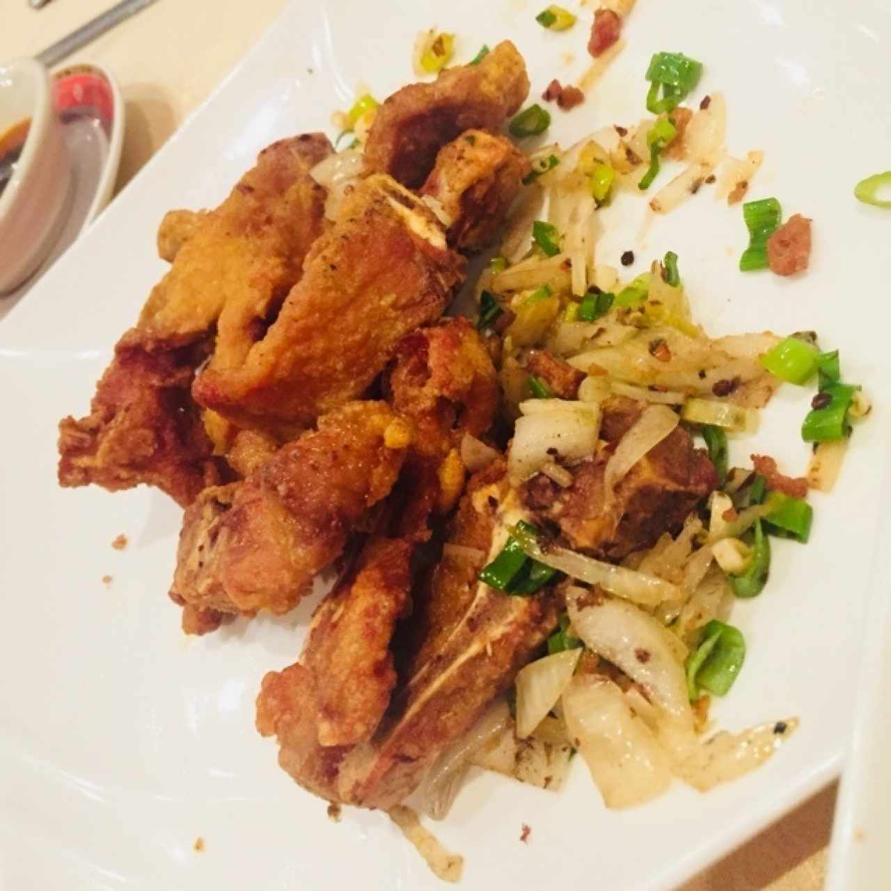 Costillas de cerdo sal y pimienta, con topping de cebolla, ají picante y cebollín.