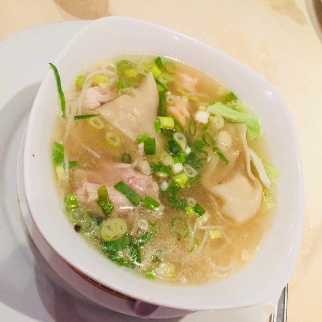 Sopa Wanton con tallarines de arroz, pollo y cebollín crocante. 