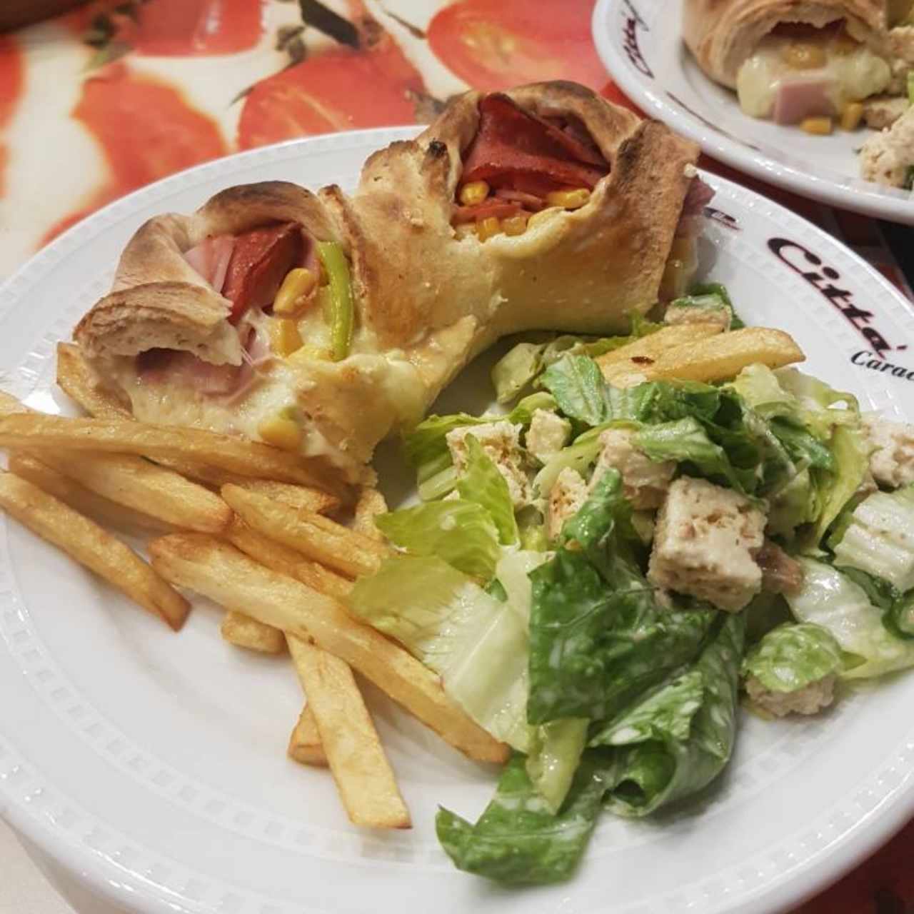 Pizza acompañada de papas y ensalada.