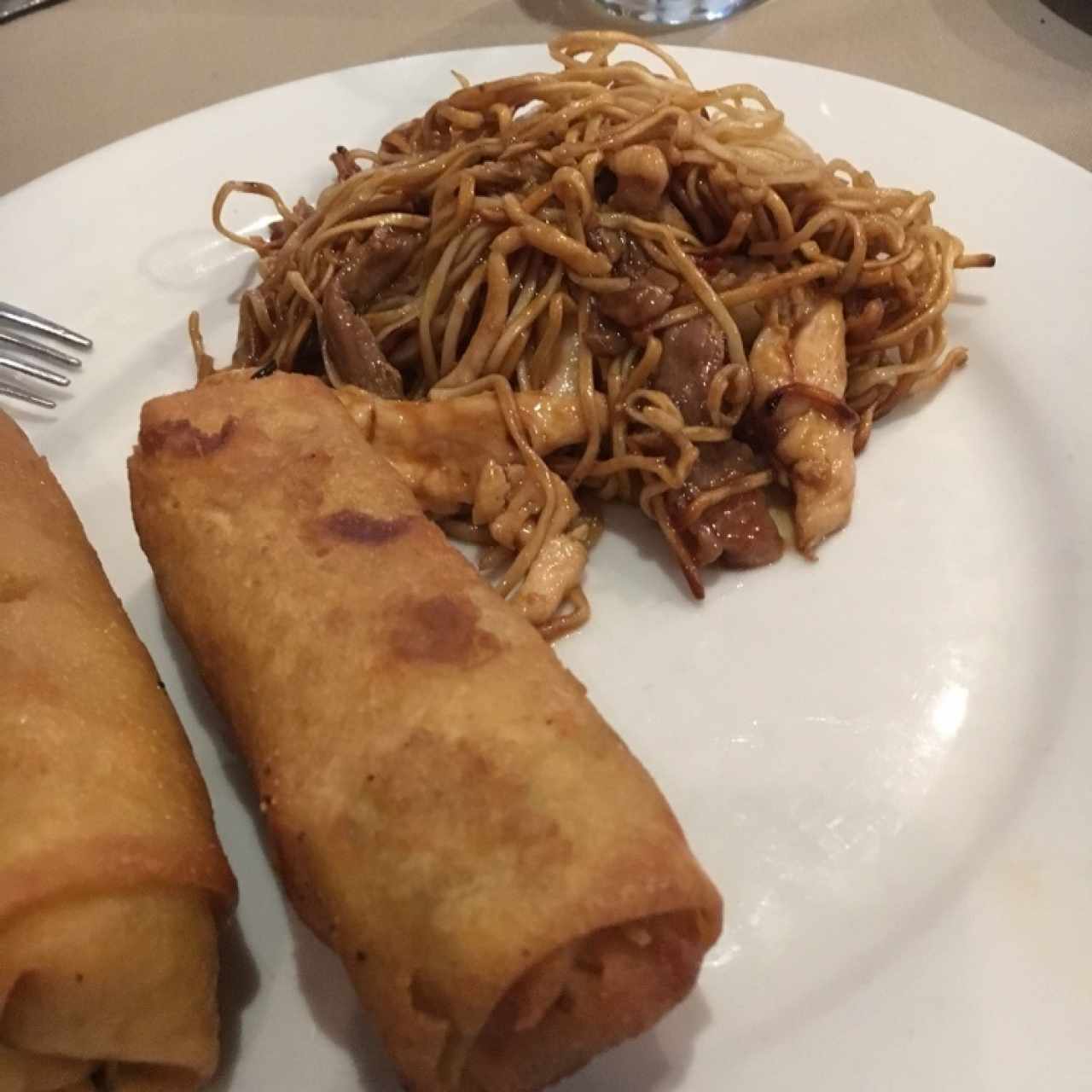 lumpia y tallarines en plato caliente