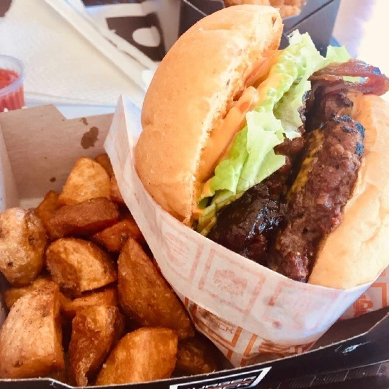 Hamburguesa doble con cebolla caramelizada y papas rústicas. 