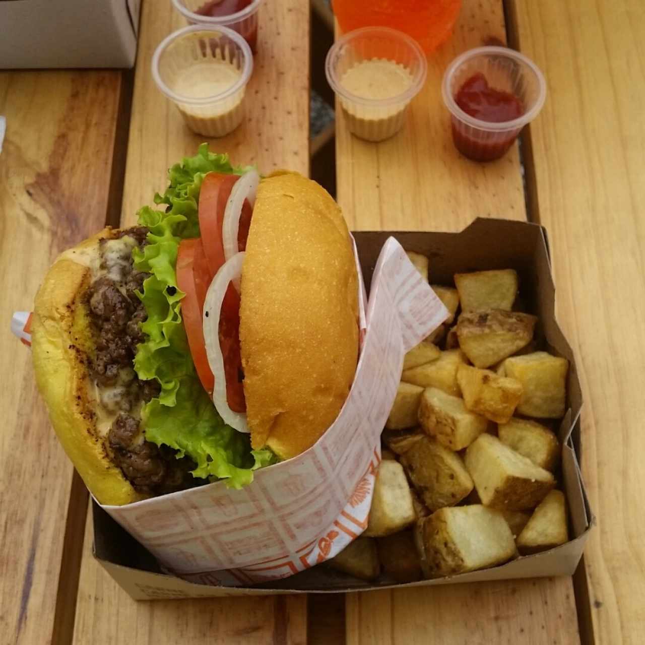 Hamburguesa Doble con queso y tocineta acompañado de papas rusticas