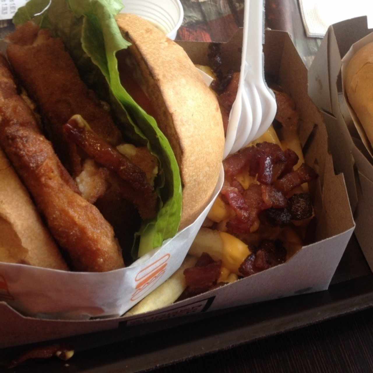 Chicken Burguer con Shack de queso crema y tocineta con papas fritas con queso y tocineta.