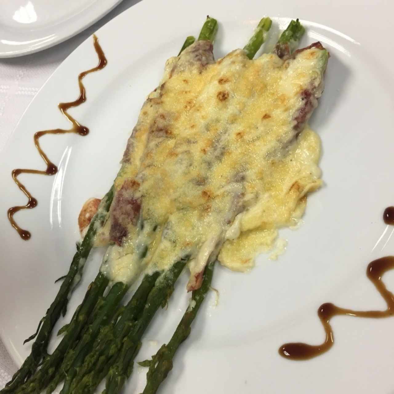 Esoarragos envueltos en jamon serrano gratinados
