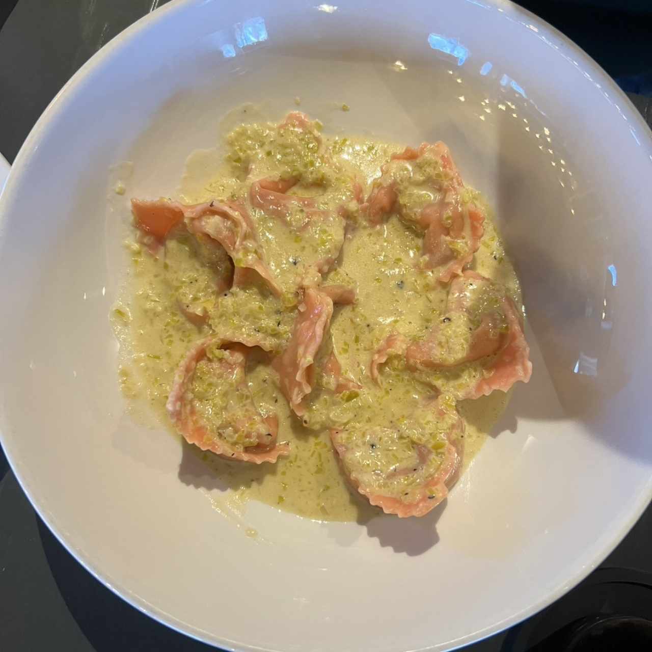 Torteloni relleno de salmón bañado en crema de ajoporro