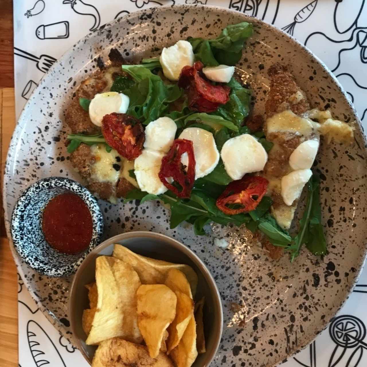 Milanessa de pollo rugula tomates secos y boconccini