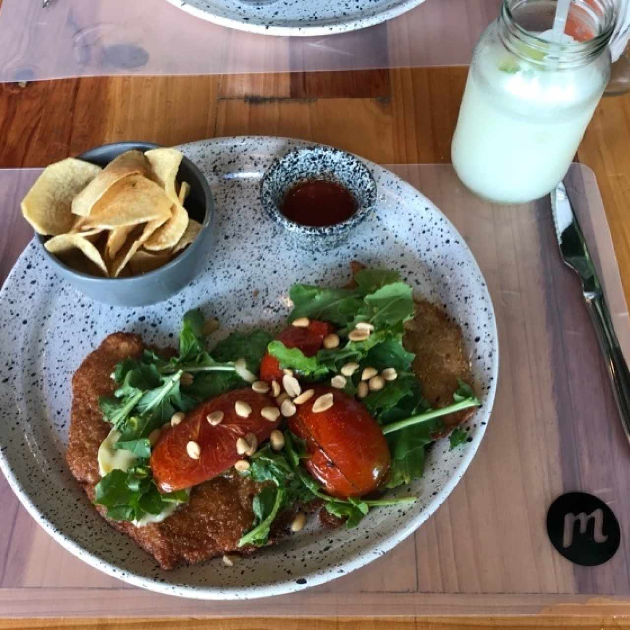 Milanesa en queso brie, miel, nueces y rugula con tomates 