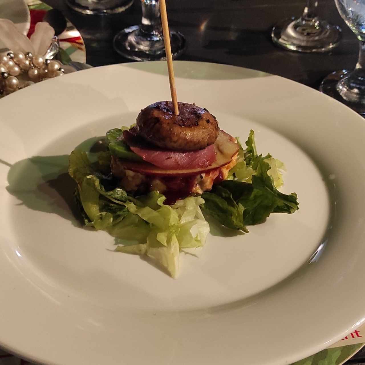 hamburguesa de pescado con tocineta ,champiñón, manzana verde en cama de lechugas. 