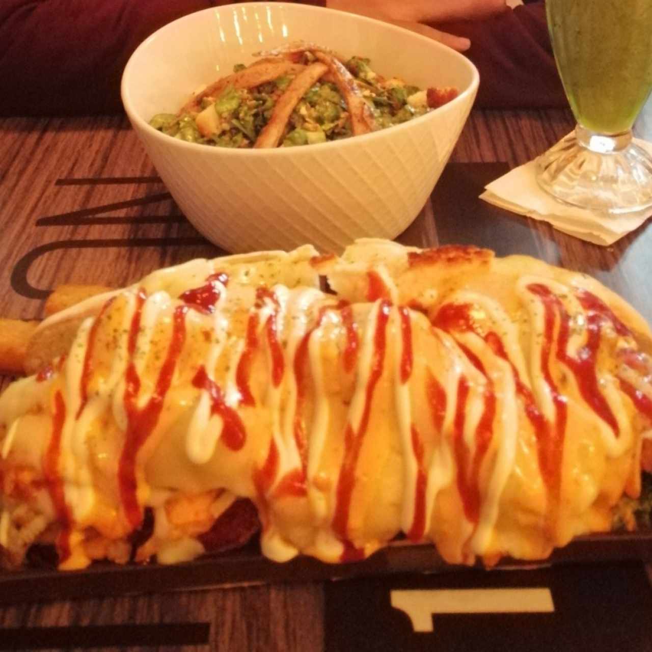 Choripán con yuca frita más ensalada Cesar.
