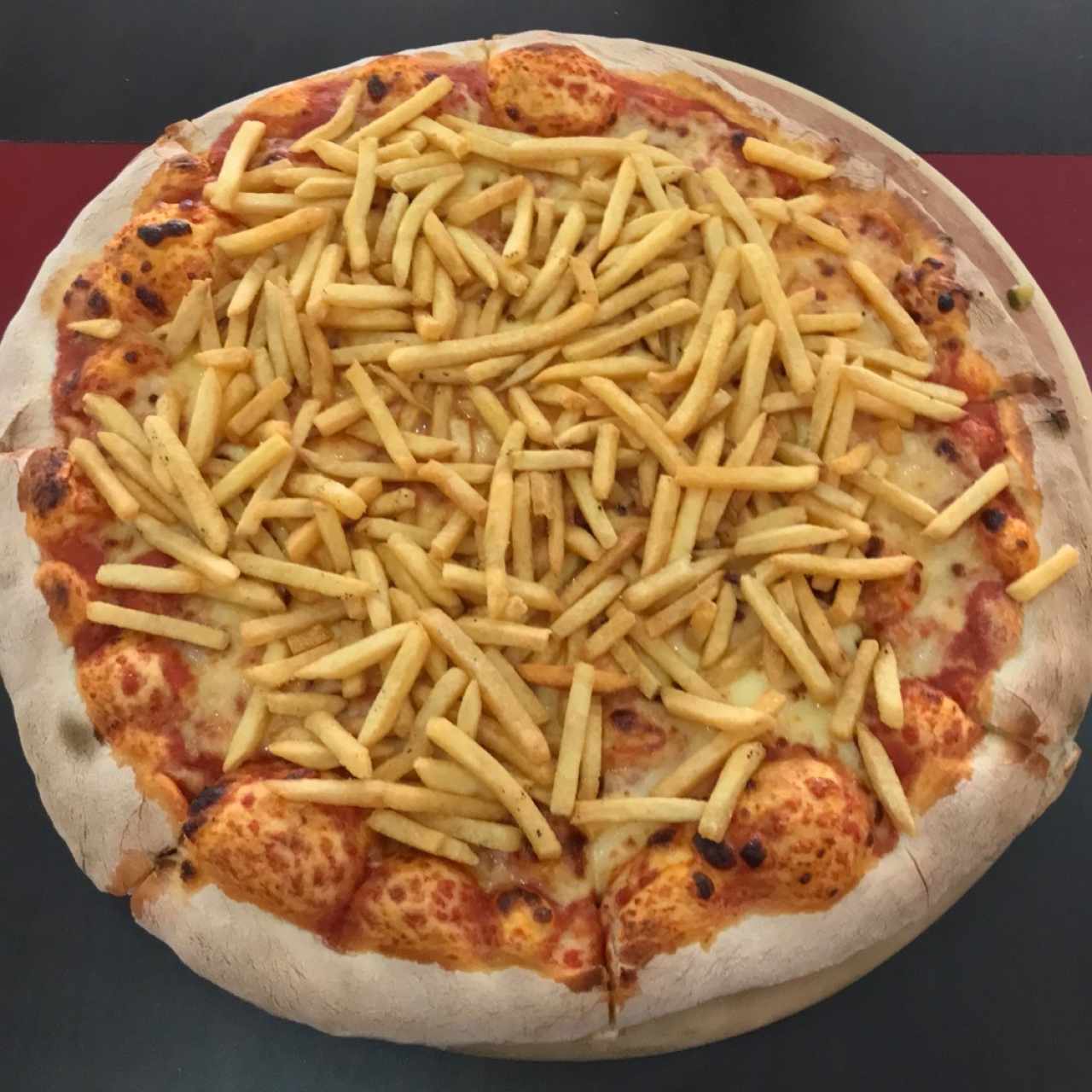 Pizza margarita con papas fritas.