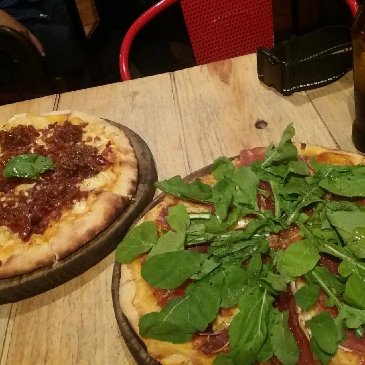 pizza jamón serrano y rugula y queso gouda con chips de tocineta y cebolla caramelizad 