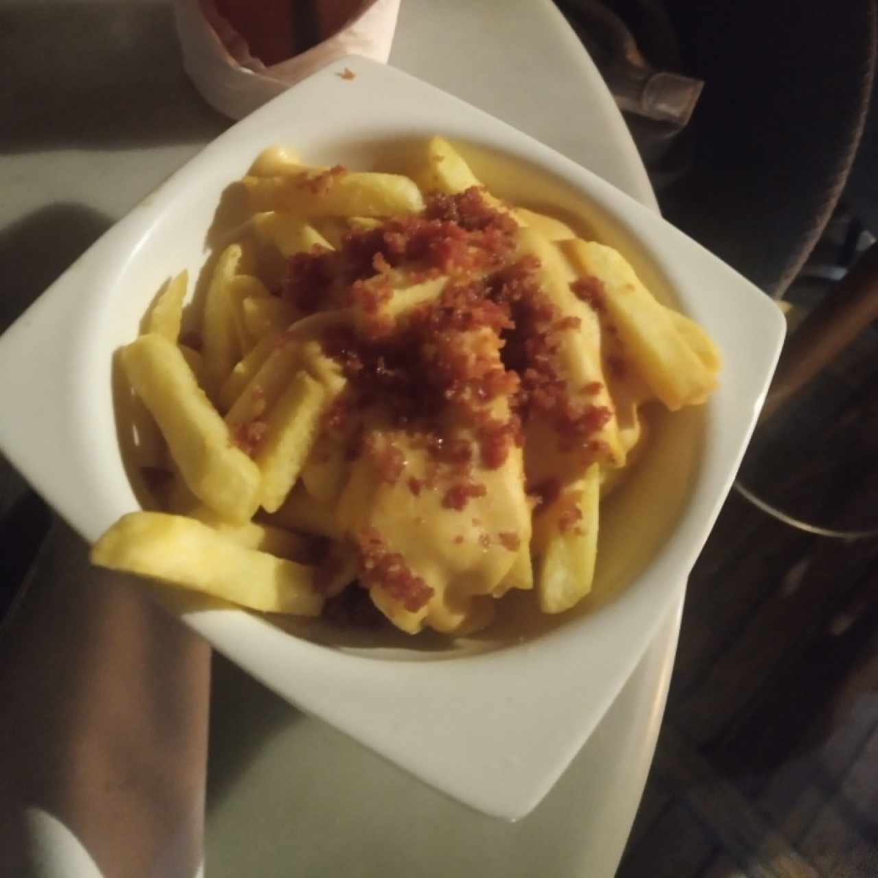 ración de papas con queso y tocineta