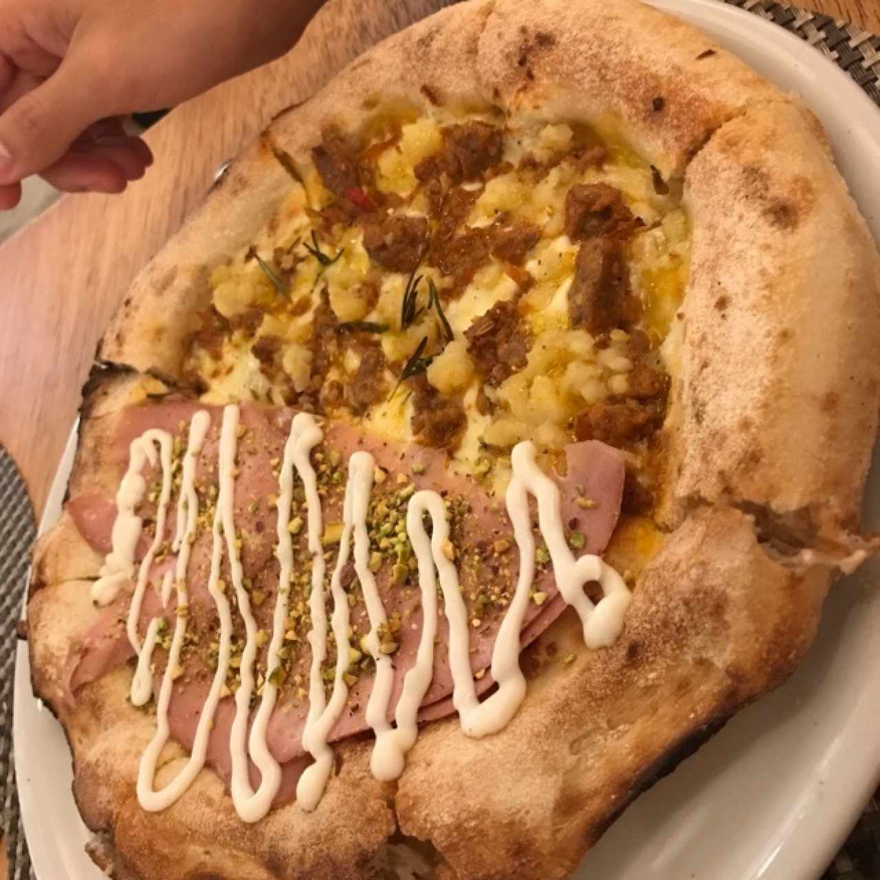 pizza mitad de mortadella con pistacho y queso ricotta, con otra mitad de pizza con salchicha, papa y romero (pizza sin salsa)