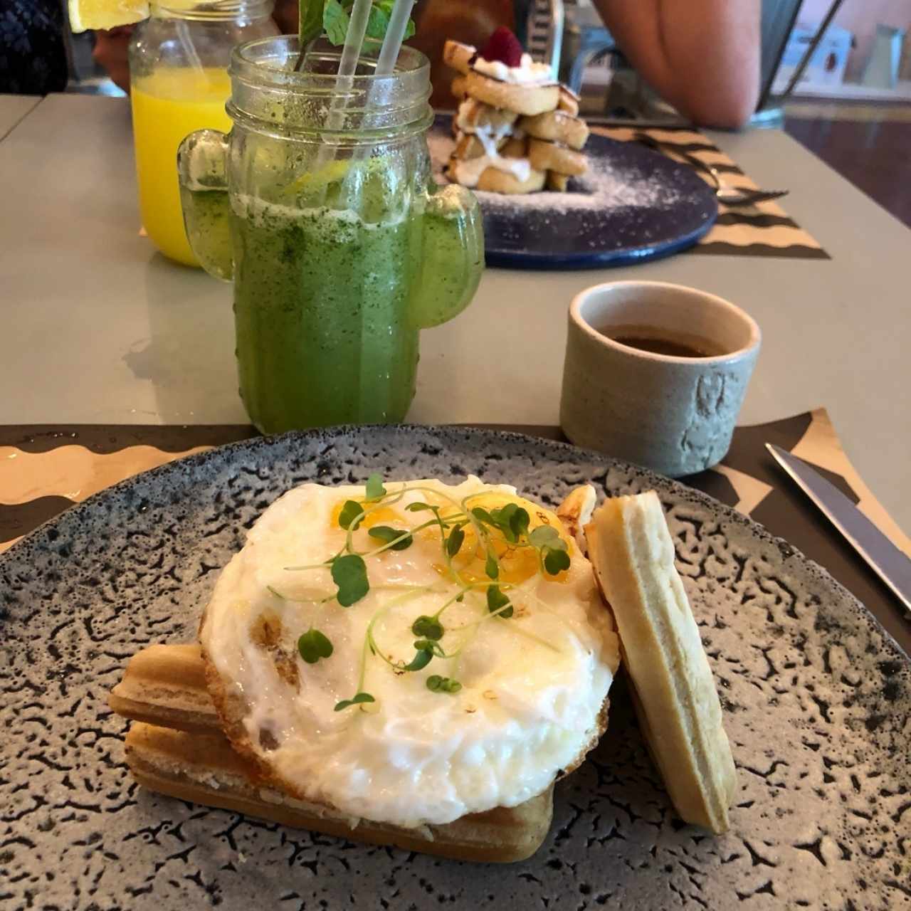 Waffles de salchicha de pollo y huevo, junto a limonada con yerbabuena 