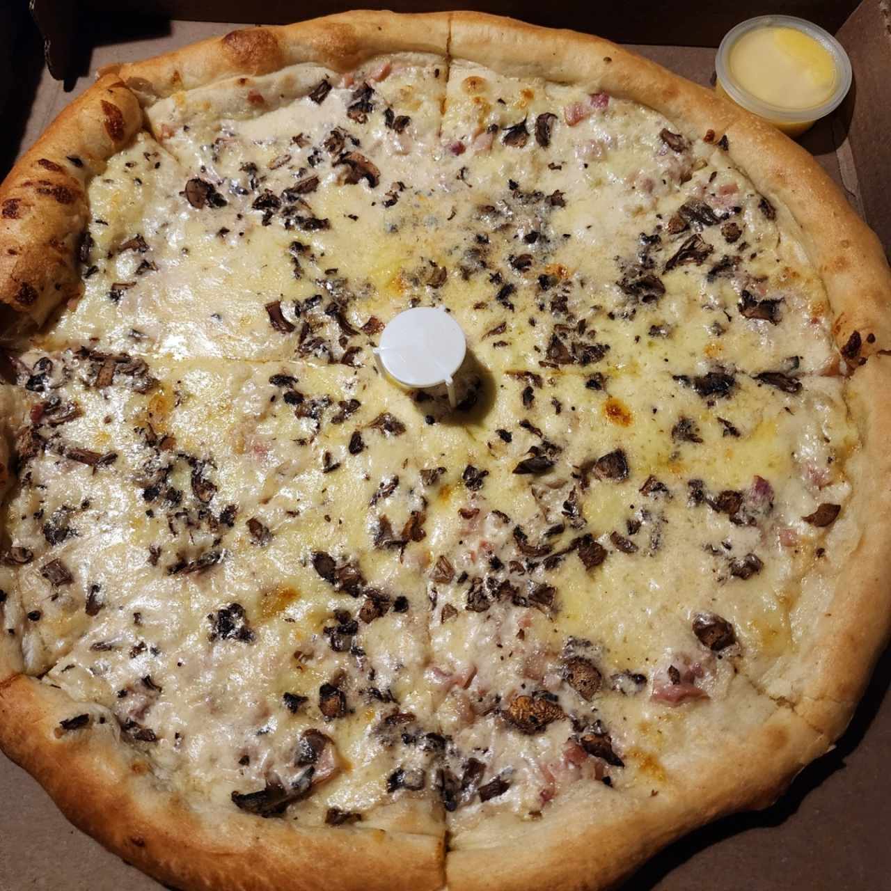 Pizza a la crema con tocineta y cebolla
